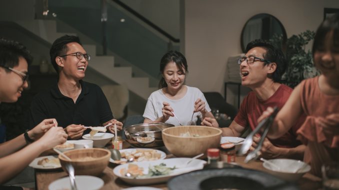 an asian chinese families and friends having night dinner gathering at home with traditional chinese steamboat dishes